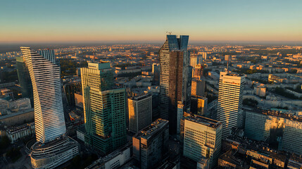 Aerial cityscape of modern downtown during golden hour with dramatic sunset and shadows