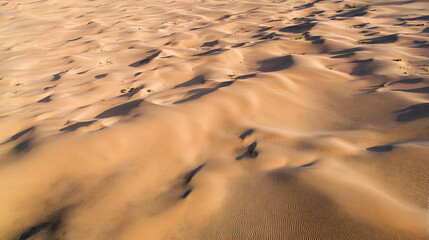 Aerial drone footage of desert sand dunes with natural textures and long shadows