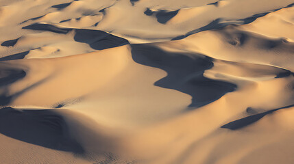 Aerial drone footage of desert sand dunes with natural textures and long shadows