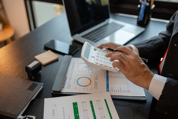 a businessman reviews the company's financial documents in his office, the accountant is rushing to check the figures in the documents before submitting them to the tax office