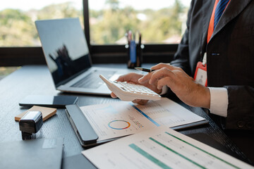 a businessman reviews the company's financial documents in his office, the accountant is rushing to check the figures in the documents before submitting them to the tax office