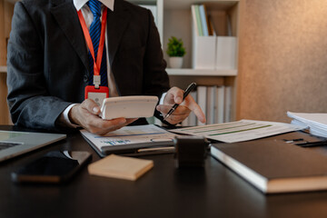 a businessman reviews the company's financial documents in his office, the accountant is rushing to check the figures in the documents before submitting them to the tax office