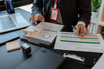 a businessman reviews the company's financial documents in his office, the accountant is rushing to check the figures in the documents before submitting them to the tax office