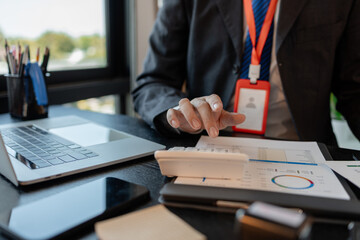 a businessman reviews the company's financial documents in his office, the accountant is rushing to check the figures in the documents before submitting them to the tax office