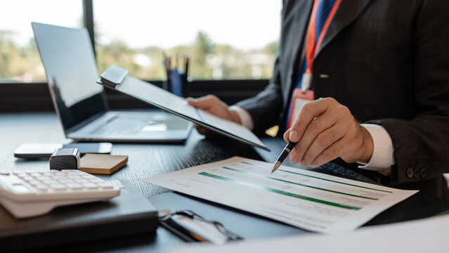 a businessman is reviewing accounting and financial statistics documents in his private office, the statistician prepares various charts and documents for a meeting