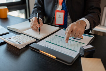 an accounting and financial officer is working on documents in the office, a businessman is reviewing his company's historical budget statistics, finance, marketing