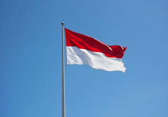 Indonesian flag waving proudly under bright blue sky during Merdeka celebration