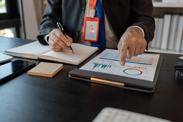 an accounting and financial officer is working on documents in the office, a businessman is reviewing his company's historical budget statistics, finance, marketing