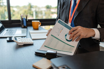 an accounting and financial officer is working on documents in the office, a businessman is reviewing his company's historical budget statistics, finance, marketing