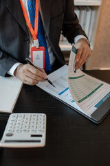 an accounting and financial officer is working on documents in the office, a businessman is reviewing his company's historical budget statistics, finance, marketing