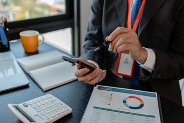 a businessman woks with a foreign company and uses a smartphone to help send and receive information, marketing manager sends statistic information to accounting department via a smartphone