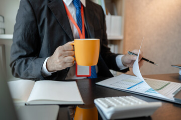 an accounting and financial officer is working on documents in the office, a businessman is reviewing his company's historical budget statistics, finance, marketing
