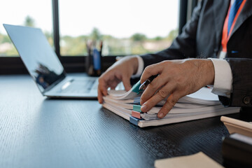 an accounting and financial officer is working on documents in the office, a businessman is reviewing his company's historical budget statistics, finance, marketing