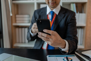 a businessman woks with a foreign company and uses a smartphone to help send and receive information, marketing manager sends statistic information to accounting department via a smartphone