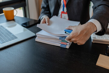 an accounting and financial officer is working on documents in the office, a businessman is reviewing his company's historical budget statistics, finance, marketing