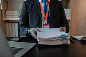 an accounting and financial officer is working on documents in the office, a businessman is reviewing his company's historical budget statistics, finance, marketing