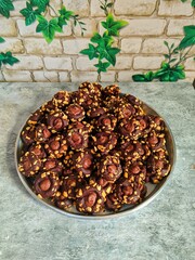 Top view of a tray filled with chocolate cookies topped with chocolate drops and crushed peanuts. Perfect for bakery, homemade treats, festive snacks, or dessert-themed content.