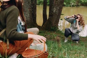 middle aged woman taking photo outdoors with friends in nature, active healthy lifestyle by river