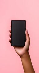 Hand holding a black power bank against a pink background.  A dark-skinned hand holds a rectangular, matte black portable charger.  The device is centered and angled slightly. 