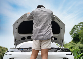 Traveler Fixing Electric Car with Possible Breakdown or Dead Battery