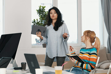young woman presenting ideas to coworkers in modern workplace, business meeting, socializing, Gen Z...
