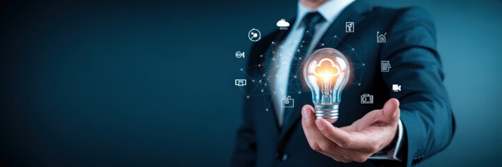 Businessman holding a glowing lightbulb with digital interface.