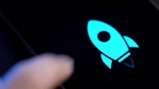 Finger taps glowing rocket launch app screen