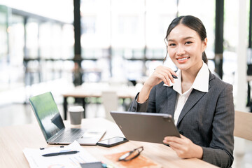 Portrait of smiling businesswoman sitting at desk in the office