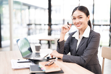 Portrait of smiling businesswoman sitting at desk in the office