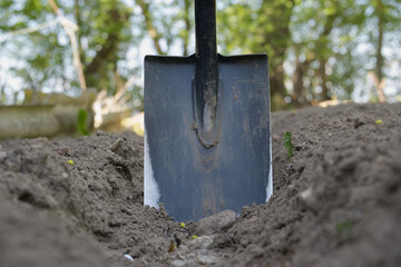 Shovel in Freshly Dug Soil in a Green Outdoor Environment