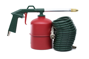 A close-up shot of an industrial air gun with a green hose and air tank on white background.