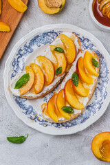 Bruschetta with ricotta cheese, sliced nectarines, basil and honey on a plate