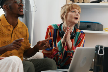young adult woman and male colleagues socializing and working together in a modern workplace,...