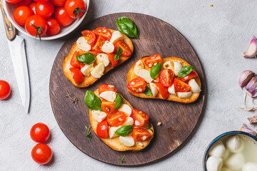 Bruschetta caprese with cherry tomatoes and mozzarella garnished with basil