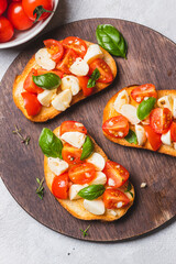 Bruschetta caprese with cherry tomatoes and mozzarella garnished with basil