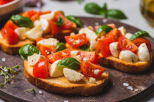 Bruschetta caprese with cherry tomatoes and mozzarella garnished with basil
