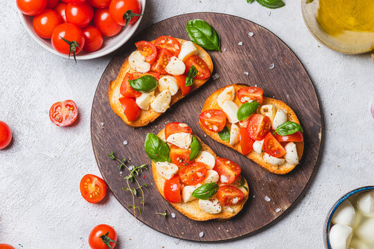 Bruschetta caprese with cherry tomatoes and mozzarella garnished with basil
