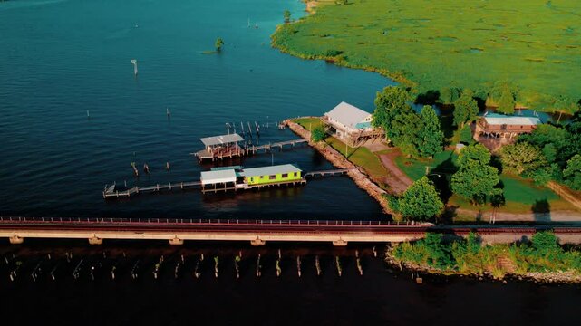 Akers, LA showing stilt cabins, boat docks, and marshy shoreline. Southern lifestyle footage. Elevated boathouse for Floating fishing camp.