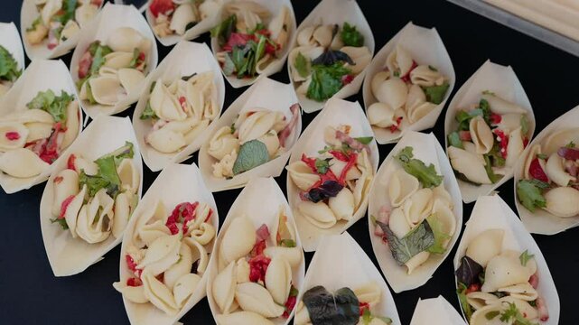 mini shell pasta salads with greens and peppers served in eco friendly disposable leaf bowls