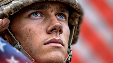 An American soldier with helmet standing at attention with American flag waving for Veterans Day and Memorial Day