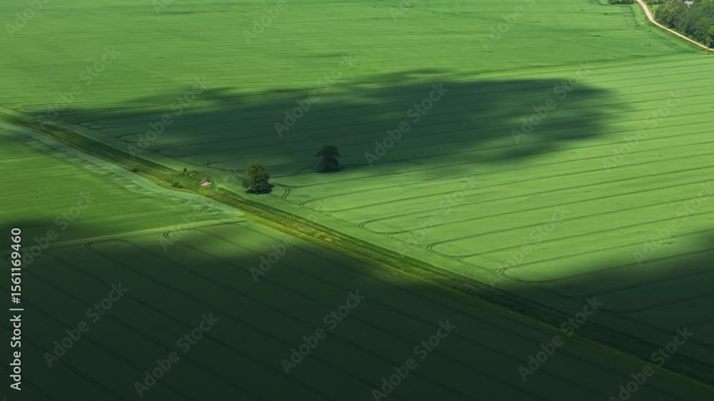 Poster drone overview of dynamic cloud patterns over a vibrant farmland landscape