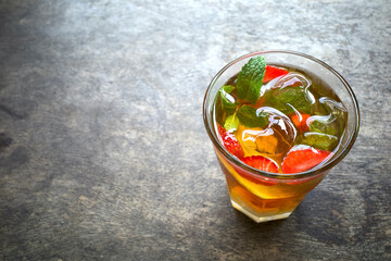 A glass of strawberry smoothie ice garnished with fresh mint and sliced strawberries