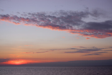 sunset in the sea. Beautiful colorful sky and cloud in twilight time background. Orange fluffy clouds and sun sunlight reflection in the blue