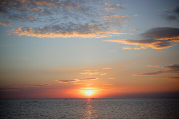 sunset in the sea. Beautiful colorful sky and cloud in twilight time background. Orange fluffy clouds and sun sunlight reflection in the blue