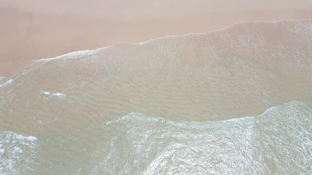 panning up from the crystal clear water to the green hills 