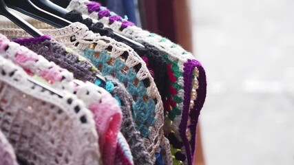 Colorful crochet garments displayed at a local market