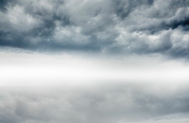 Flat design showing storm cloudscape reflecting on calm open-water surface under misty horizon