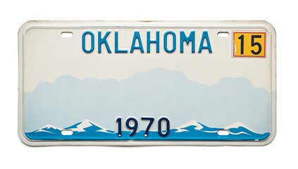 Vintage 1970 Oklahoma license plate with bold blue letters. Features mountains and a yellow registration sticker with "15" in the top right