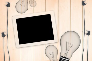 Bulbs and tablet on wooden background