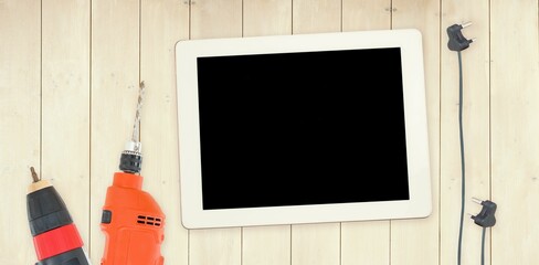 Tools and tablet on wooden background